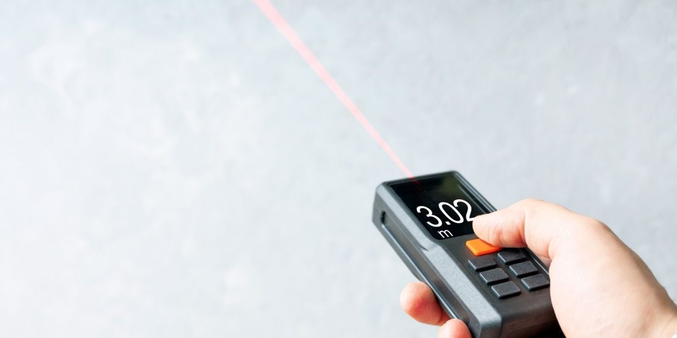 Main tenant un télémètre laser Bosch lors d'un diagnostic immobilier de précision à Montpellier
